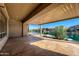 Covered patio overlooking a lake with manicured landscaping at 42625 W Sandpiper Dr, Maricopa, AZ 85138