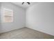 Clean, minimalist bedroom with neutral carpet, bright window, and ceiling fan; a serene space at 4314 E Bernice St, Gilbert, AZ 85295