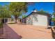 Expansive backyard with pristine gravel, mature shade trees and rear view of covered patio at 48 S Catalina St, Gilbert, AZ 85233