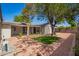 Spacious backyard featuring decorative gravel, mature trees, and a charming covered patio, perfect for outdoor relaxation at 48 S Catalina St, Gilbert, AZ 85233