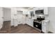 Modern kitchen with stainless steel appliances, white cabinets, and laminate wood flooring at 48 S Catalina St, Gilbert, AZ 85233