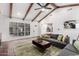 Open concept living room featuring exposed beams, stylish furniture, and brick flooring at 48 S Catalina St, Gilbert, AZ 85233