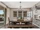 Inviting dining room featuring a wooden table, decorative chandelier, and large windows for natural light at 5051 S Moccasin Trl, Gilbert, AZ 85298