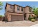 Two-story home boasting a well-maintained exterior with a brick-paved driveway and a two-car garage at 5051 S Moccasin Trl, Gilbert, AZ 85298