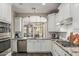 Bright kitchen with white cabinetry, stainless steel appliances, granite countertops, and modern pendant lighting at 5051 S Moccasin Trl, Gilbert, AZ 85298