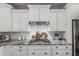 Close up of a bright kitchen with white cabinetry, granite countertops, subway tile backsplash, and a gas cooktop at 5051 S Moccasin Trl, Gilbert, AZ 85298