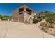 Stucco two-story home featuring a two-car garage and barrel tile roof against a clear blue sky at 6010 E Languid Ln, Carefree, AZ 85377