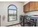 Well-lit laundry room featuring modern washer and dryer set and arched window at 6010 E Languid Ln, Carefree, AZ 85377