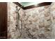 Close-up of a walk-in shower with decorative stone tiling and a built-in shower bar at 631 Leisure World --, Mesa, AZ 85206