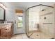 Bright bathroom boasting travertine flooring, a walk-in shower with glass blocks, and access to the outdoors at 6417 E Kings Ave, Scottsdale, AZ 85254
