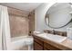 Cozy bathroom featuring tile surround, a round mirror, and a vanity with brown countertop at 6417 E Kings Ave, Scottsdale, AZ 85254