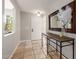 Inviting foyer with tile flooring, natural lighting, a console table with decor, and a large mirror at 6417 E Kings Ave, Scottsdale, AZ 85254