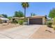 Single-story home featuring desert landscaping, a brick facade, and a two-car garage with a concrete driveway at 6417 E Kings Ave, Scottsdale, AZ 85254