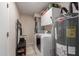 Functional laundry room with washer, dryer, water heater, and shelving for storage at 6417 E Kings Ave, Scottsdale, AZ 85254