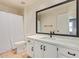 Clean bathroom featuring white cabinetry, dark hardware, a large mirror, and a shower with a white shower curtain at 7108 W Morrow Dr, Glendale, AZ 85308