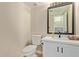 Bathroom featuring a toilet, sink, vanity, and framed mirror at 7108 W Morrow Dr, Glendale, AZ 85308