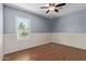 Bedroom features hardwood flooring, a ceiling fan, base trim, and a sunlit window looking to exterior greenery at 7108 W Morrow Dr, Glendale, AZ 85308