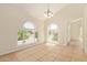 Bright dining area with vaulted ceilings, tile floors, stylish chandelier, and large arched windows at 7108 W Morrow Dr, Glendale, AZ 85308
