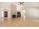 Spacious living room with vaulted ceilings, stone fireplace, tile floors, and a ceiling fan at 7108 W Morrow Dr, Glendale, AZ 85308