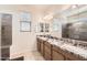 Bathroom boasts dual sinks, granite counters, and a walk-in shower with neutral tile at 7665 W Fetlock Trl, Peoria, AZ 85383