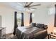 Comfortable bedroom featuring plush carpet, neutral walls, large window, and a ceiling fan at 7665 W Fetlock Trl, Peoria, AZ 85383