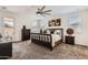 Bright bedroom boasting neutral décor, plush carpet, a ceiling fan, and a glass door to the patio at 7665 W Fetlock Trl, Peoria, AZ 85383