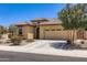 Beautiful tan home featuring a tile roof, desert landscaping, and an attached two-car garage at 7665 W Fetlock Trl, Peoria, AZ 85383