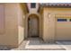 Close-up view of the home's entrance, showcasing an arched doorway and desert landscaping at 7665 W Fetlock Trl, Peoria, AZ 85383