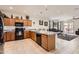 Functional kitchen featuring an island with seating and a view into the living room at 7665 W Fetlock Trl, Peoria, AZ 85383