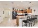 Well-lit kitchen features an island with seating, stainless steel appliances, and ample cabinet space at 7665 W Fetlock Trl, Peoria, AZ 85383