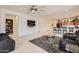 Open-concept living room with tile floors, ceiling fan, and views into the kitchen at 7665 W Fetlock Trl, Peoria, AZ 85383