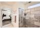 An ensuite bathroom featuring a walk-in shower with neutral tile and a glass door at 7665 W Fetlock Trl, Peoria, AZ 85383