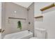Bathroom showcasing a tiled shower/bathtub combination with wood shelving and modern fixtures at 7685 W San Miguel Ave, Glendale, AZ 85303