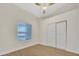 Bedroom featuring a ceiling fan, hardwood floors, natural light, and a closet with sliding doors at 7685 W San Miguel Ave, Glendale, AZ 85303