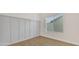 Bedroom with light gray wall paneling, wood-look flooring, and window at 7685 W San Miguel Ave, Glendale, AZ 85303