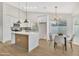 Bright kitchen and dining area boasts white cabinets, quartz counters, an island, and a modern chandelier at 7685 W San Miguel Ave, Glendale, AZ 85303