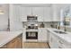 Updated kitchen features white shaker cabinets, stainless appliances, quartz countertops, and gray subway tile backsplash at 7685 W San Miguel Ave, Glendale, AZ 85303