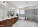 Elegant bathroom featuring a soaking tub, separate shower, and dual sinks at 8027 W Northview Ave, Glendale, AZ 85303
