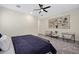 Spacious bedroom featuring neutral color palette, statement wall art, a modern ceiling fan, and two armchairs at 8027 W Northview Ave, Glendale, AZ 85303