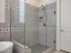 This modern shower offers stylish tile, rainfall shower head, glass door, and built-in niche shelving at 8027 W Northview Ave, Glendale, AZ 85303