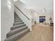 Bright living room with open staircase and laminate floors connects to a cozy seating area with ceiling fan at 8619 N 67Th Dr, Peoria, AZ 85345
