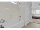 The bright bathroom has a white bathtub with shower, neutral colors, and a calming ambiance at 8753 E Plata Ave, Mesa, AZ 85212