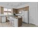 The kitchen has wooden cabinets, white appliances, and a breakfast bar with white modern chairs at 8753 E Plata Ave, Mesa, AZ 85212