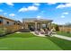 Charming backyard oasis with artificial turf, an outdoor grill, a covered patio, and a brick fire pit at 8820 E Ivy Cir, Mesa, AZ 85207