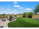 Inviting backyard featuring a synthetic lawn, brick patio, and a cozy fire pit area, perfect for outdoor entertaining at 8820 E Ivy Cir, Mesa, AZ 85207