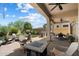 Covered patio with bar, outdoor dining set and fireplace in a landscaped backyard at 8820 E Ivy Cir, Mesa, AZ 85207