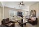 Cozy living room featuring plantation shutters, a ceiling fan, and neutral decor at 8820 E Ivy Cir, Mesa, AZ 85207