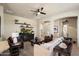Bright living room with a ceiling fan, decorative shelves, and easy access to other rooms at 8820 E Ivy Cir, Mesa, AZ 85207