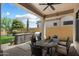 Outdoor kitchen and bar area plus a wrought iron table and chairs set on brick patio at 8820 E Ivy Cir, Mesa, AZ 85207