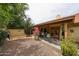 Cozy backyard with a covered patio, dining set, gravel ground cover, and mature landscaping create a peaceful retreat at 9085 E Windrose Dr, Scottsdale, AZ 85260